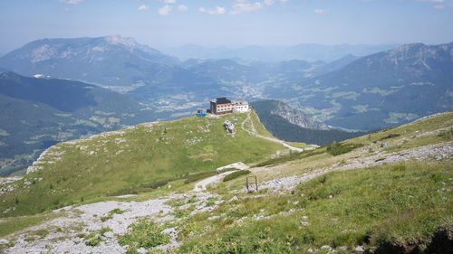 Alpine hut towering high above beautiful green valley surrounded by mountains , watzmanhaus