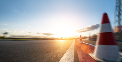 Blurred motion of airplane on road against sky during sunset