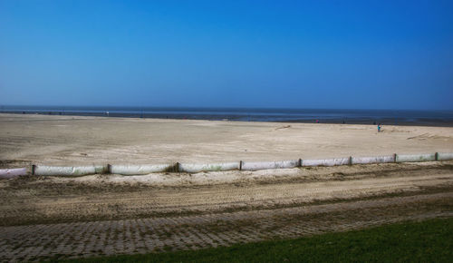 Scenic view of beach against clear blue sky