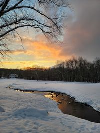 Scenic view of snow covered landscape against sky during sunset