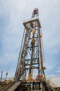 Low angle view of cranes against sky