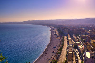 High angle view of city by sea during sunset