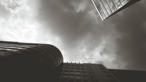 Low angle view of modern building against cloudy sky