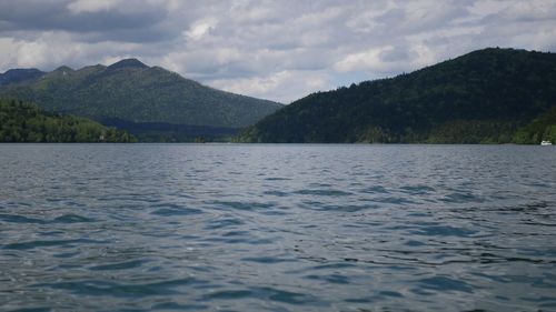 Scenic view of lake by mountains against sky