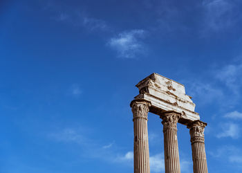 Low angle view of old ruins against blue sky