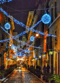 Illuminated christmas lights against sky at night