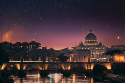 Illuminated buildings against sky at night