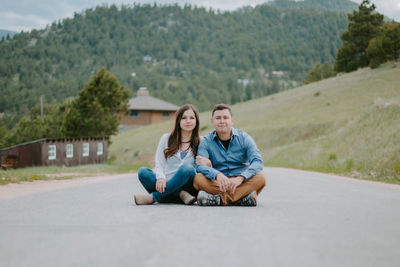 Young couple sitting outdoors in the middle of a street