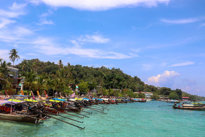 Sailboats moored on sea against sky