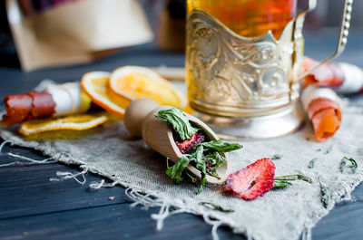 Green tea leaves with strawberry in a wooden spoon