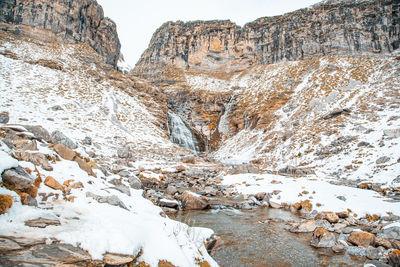 Snow covered rocks against mountain