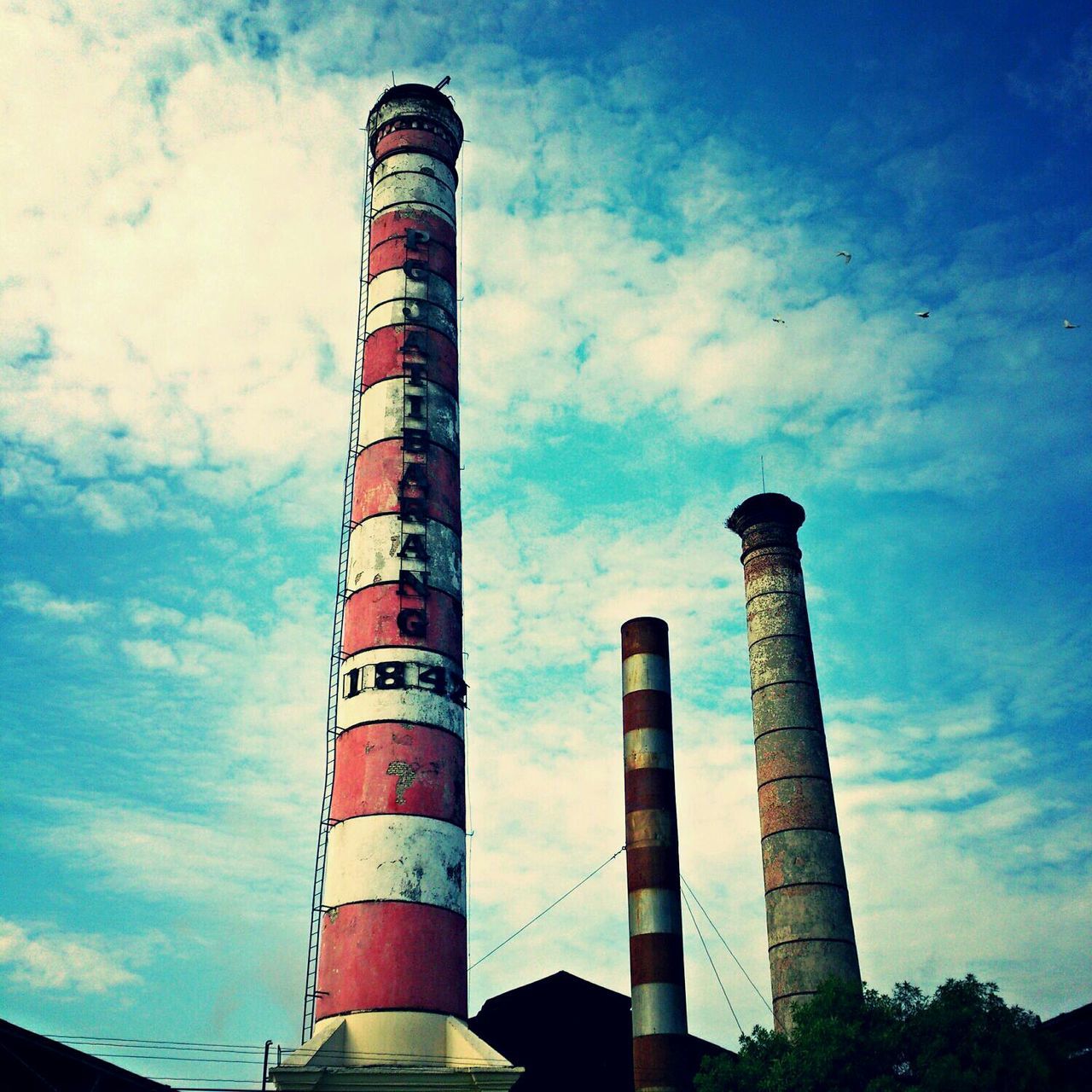 sky, low angle view, architecture, built structure, blue, building exterior, cloud - sky, cloud, industry, smoke stack, cloudy, red, no people, tall - high, guidance, pole, outdoors, day, tower, factory