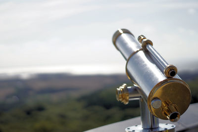 Close-up of coin-operated binoculars against sky