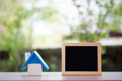 Close-up of model house and blackboard on table