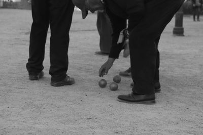 Man picking up ball from ground