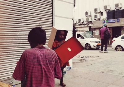 Rear view of people walking on street in city