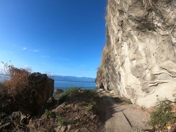 Scenic view of sea and mountains against blue sky