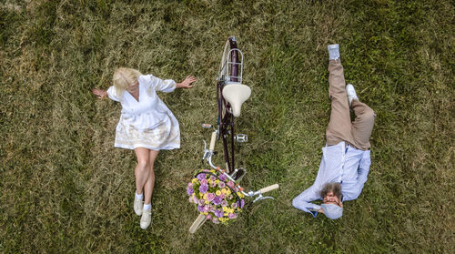 High angle view of friends lying on field