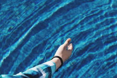 High angle view of human hand on swimming pool
