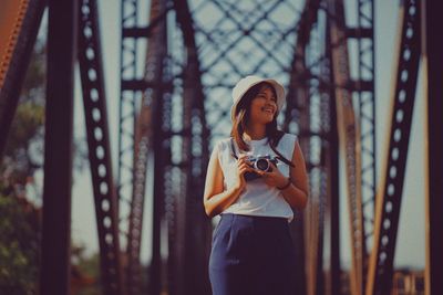 Woman looking at camera while standing in forest