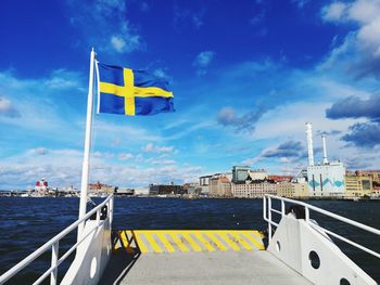 Yellow flag against blue sky in city