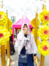 Full length of woman standing against yellow wall