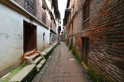 Empty alley amidst buildings in city