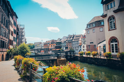 Canal amidst buildings in city against sky