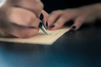 Close-up of hand holding paper with text