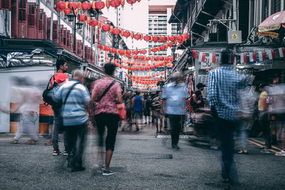 Rear view of people walking on city street