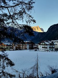 Houses by snow covered mountains against sky