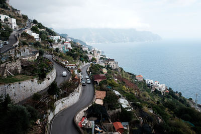 High angle view of buildings by sea against sky