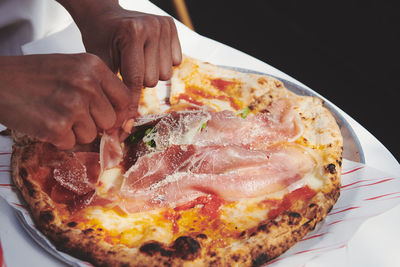 Close-up of hand holding pizza