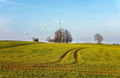 Windmill on field against sky