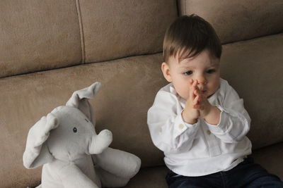 Cute baby sitting on sofa at home