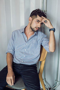 Portrait of young man sitting at home