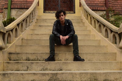 Portrait of young man sitting on stairs