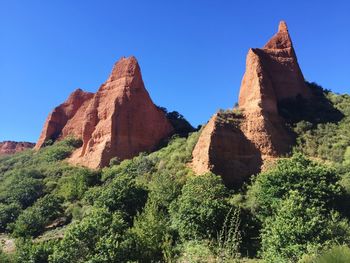 Low angle view of mountain against blue sky