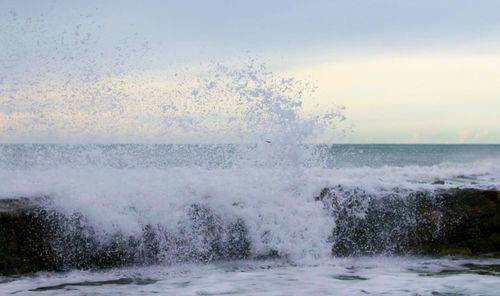 Close-up of sea waves splashing against sky