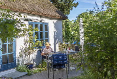 Senior man relaxing in front of house