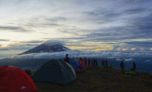 Group of people on snowcapped mountain against sky