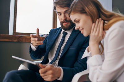 Business people using digital tablet while sitting at office