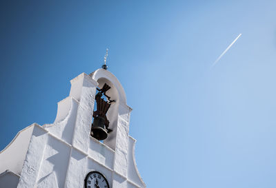 Low angle view of bell tower against blue sky