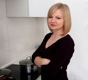 Portrait of young woman standing in kitchen