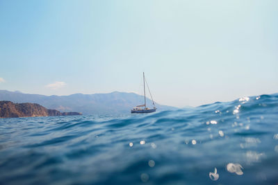 Sailboats sailing in sea against sky