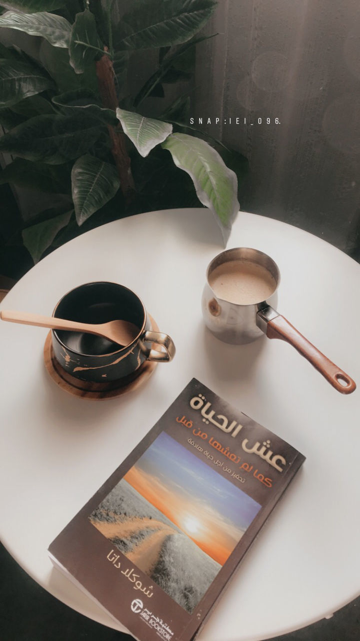 table, mug, cup, indoors, communication, text, coffee cup, glasses, drink, refreshment, high angle view, plant part, food and drink, leaf, western script, close-up, plant, coffee - drink, publication, coffee, no people, tea cup, crockery