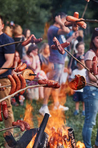 Roasting sausages over fireplace