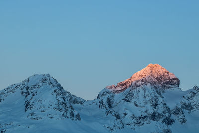 Scenic view of snowcapped mountains against clear blue sky