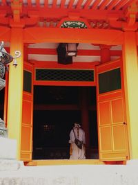 Rear view of man standing at entrance of building