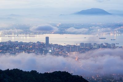 Panoramic view of city against cloudy sky